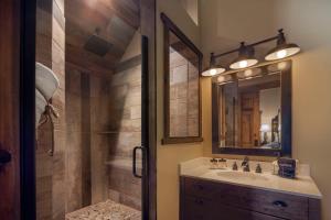 La salle de bains est pourvue d'un lavabo et d'une douche avec un miroir. dans l'établissement River Rock Inn B&B, à Green River