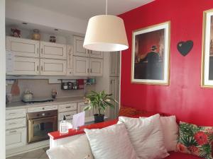 a living room with a couch and a red wall at Casa Magnolia in Varese