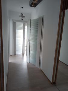 einen leeren Flur mit Türen und einem Spiegel in der Unterkunft Apartament Sądecki in Nowy Sącz