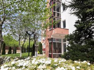 a building with white flowers in front of it at Kalina Private Apartments in Riviera Fort Beach, Ravda in Ravda