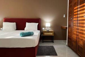 ein Schlafzimmer mit einem Bett mit einem blauen Kissen darauf in der Unterkunft Maya Plage, Villa en bord de mer in Cap Skirring