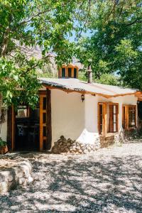 a small white house with a tree at Cabañas El Palomar in San Alfonso