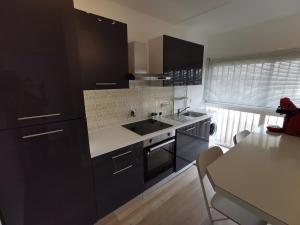 a kitchen with black cabinets and a white counter top at Antibes studio Vauban dernier étage vue mer in Antibes