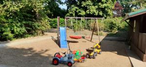 um parque infantil com brinquedos e um baloiço em Vogtkate em Damlos