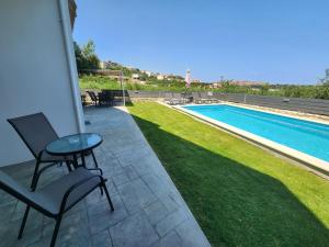 a patio with a table and chairs next to a swimming pool at Villa Dionisia with private pool in Roumelí