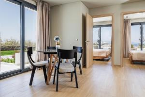ein Esszimmer mit einem Tisch und Stühlen sowie ein Schlafzimmer in der Unterkunft El Mar Naxos in Naxos Chora