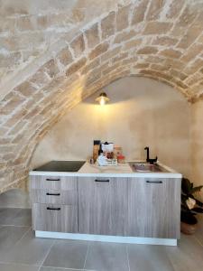 una cucina con lavandino e parete in pietra di Cavatelli a Petacciato