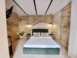una camera con un grande letto in un muro di mattoni di Cavatelli a Petacciato