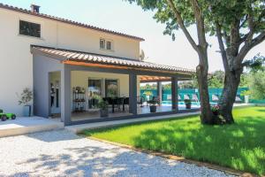 a house with a patio and a yard with a tree at Wonderful villa wit pool surrounded by nature, high level of privacy a few minutes to the beach and town center by car by WiiBuk in Valtura