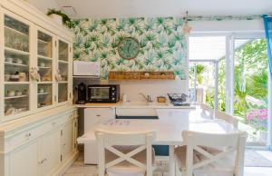 cocina con mesa y reloj en la pared en Escale et bien-être en Pornic