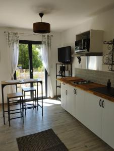 kuchnia z białymi szafkami i stołem z krzesłami w obiekcie Studio de charme en Provence w mieście Caromb