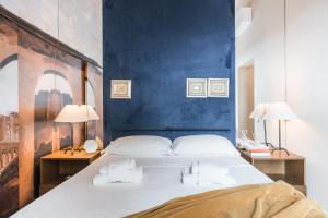 a bedroom with a large bed with a blue wall at The Best Rent - Spacious apartment with terraces with panoramic view of Rome in Rome