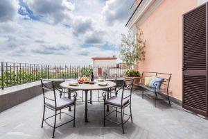 a patio with a table and chairs on a balcony at The Best Rent - Spacious apartment with terraces with panoramic view of Rome in Rome