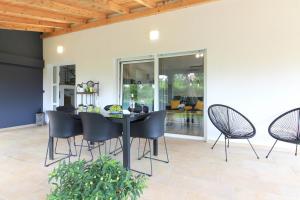 uma sala de jantar com uma mesa preta e cadeiras em Wonderful villa wit pool surrounded by nature, high level of privacy a few minutes by the beach and town center by car em Valtura