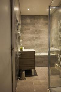 a bathroom with a tub and a sink and a shower at HÔTEL LE CHAPON FIN in Moissac