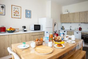 una cocina con una mesa de madera con comida. en Bel appartement, bien équipé et confortable dans le centre historique en Fougères