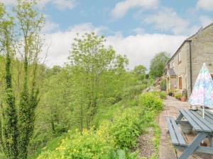 a picnic table in a garden next to a building at New Cottage in Bakewell