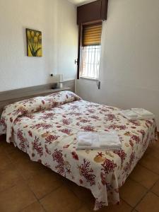 a bedroom with a bed with a flowered blanket at Salemarino apartment in Terrauzza