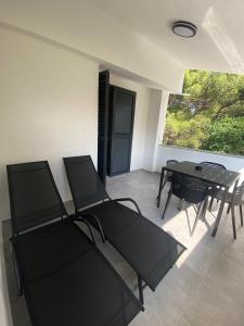 a dining room with a table and chairs and a window at Apartmani Kim in Starigrad +24 photos