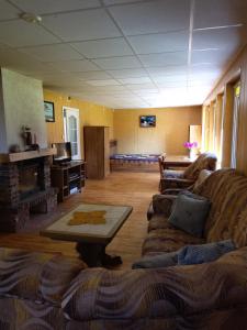 a living room with a couch and a table at Petronių sodyba in Rukliai