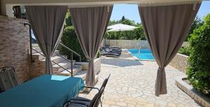 a patio with a table and chairs and a pool at Villa Karla in Jadranovo