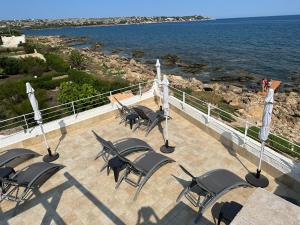a group of chairs sitting on a patio by the water at Salemarino apartment in Terrauzza