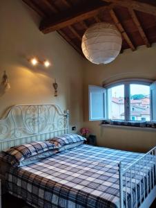 una camera da letto con un grande letto con una coperta a quadri di La casetta a Pieve a Nievole