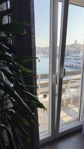 una porta aperta su un balcone con vista sull'oceano di DIIO Suites a Ermoupoli