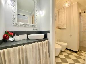 a bathroom with a sink and a toilet and a mirror at CasaViva - Le Vele di Angela in Genoa
