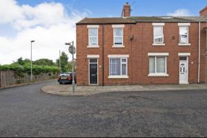 a brick house with a car parked in the driveway at The Elderton, Newbiggin By The Sea, Northumberland in Newbiggin-by-the-Sea