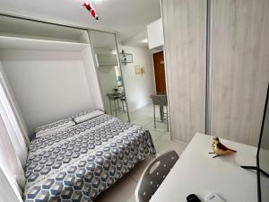 1 dormitorio con 1 cama, mesa y sillas en Golden Point, en Recife