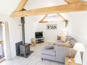 a living room with a couch and a wood stove at The Chicken Shed in Warwick