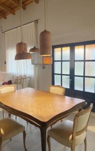 a dining room with a wooden table and chairs at La Pasiva in Villa Giardino