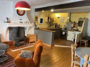 a kitchen and living room with a couch and a fireplace at Chez mamie Nénette in Barrême