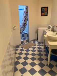 baño con suelo de color azul y blanco a cuadros en Chez mamie Nénette, en Barrême