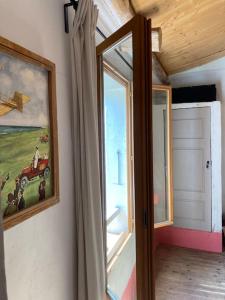 une chambre avec une fenêtre et une peinture d'un tracteur dans l'établissement Chez mamie Nénette, à Barrême