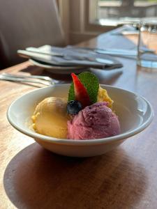 a bowl of ice cream with fruit on a table at Garth Hotel in Grantown on Spey
