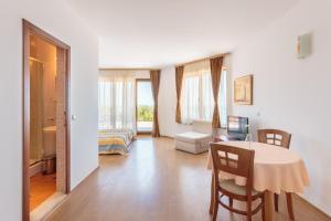 sala de estar con mesa y dormitorio en Via Pontica 123 Guest Apartments, en Sozopol