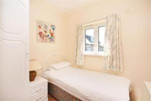 una piccola camera con letto e finestra di Direct Beach Access! Top Floor Apartment Perranporth a Perranporth