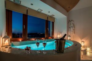 a bathroom with a tub with glasses of wine at William's Houses in Akrotiri