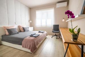 a small bedroom with a bed and a desk at City Center apartament “MARTA” in Varna City