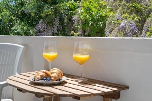 due bicchieri di succo d'arancia e un piatto di cibo su un tavolo di B&B Arba a Barbat na Rabu