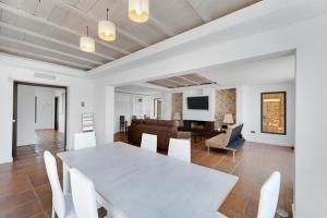 a dining room and living room with a white table and chairs at Villa Mateos in Ronda