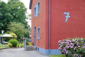 un edificio rojo con un cartel junto a las flores en Ferienwohnung Mitten im Pott, en Bottrop