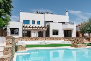 a villa with a swimming pool in front of a house at Villa Mateos in Ronda