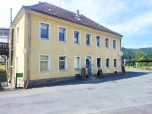 a yellow building on the side of a street at Ferienwohnung 2 am Hofladen Hellendorf in Bad Gottleuba