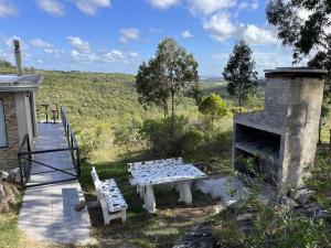 una mesa de picnic y un banco en un patio en Sol de Elefantes, en Villa Serrana