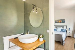 a bathroom with a sink and a tub and a bed at The Pearl of the sea in Porto Columbu - Perdʼe Sali