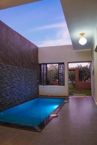 a swimming pool in the middle of a house at Douiria salix agafay in Marrakech