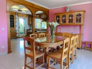 a dining room with a table and chairs and pink walls at Villa Remoan in Vilagarcia de Arousa
